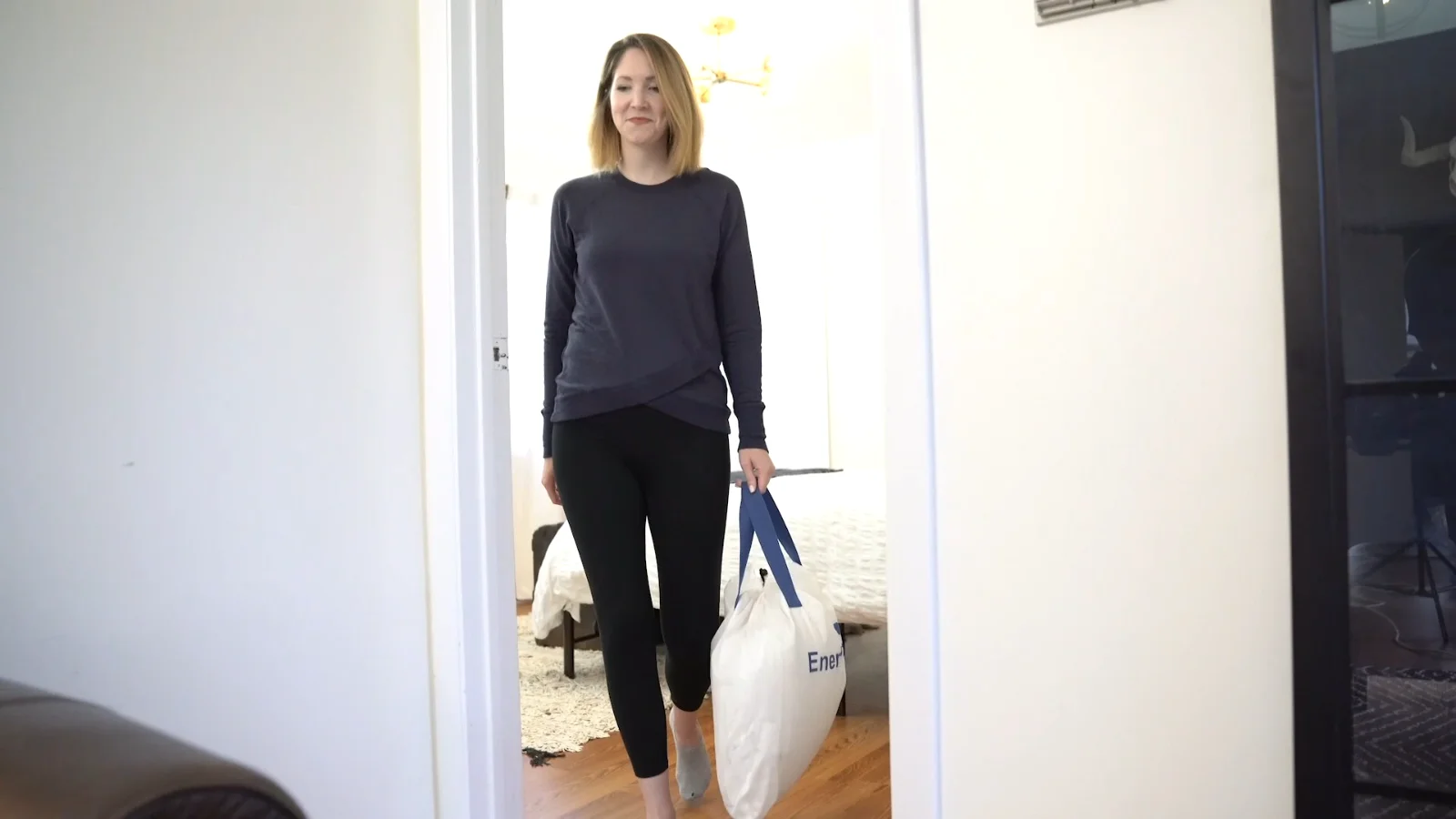 Through the door: a bed for the night in one hand.