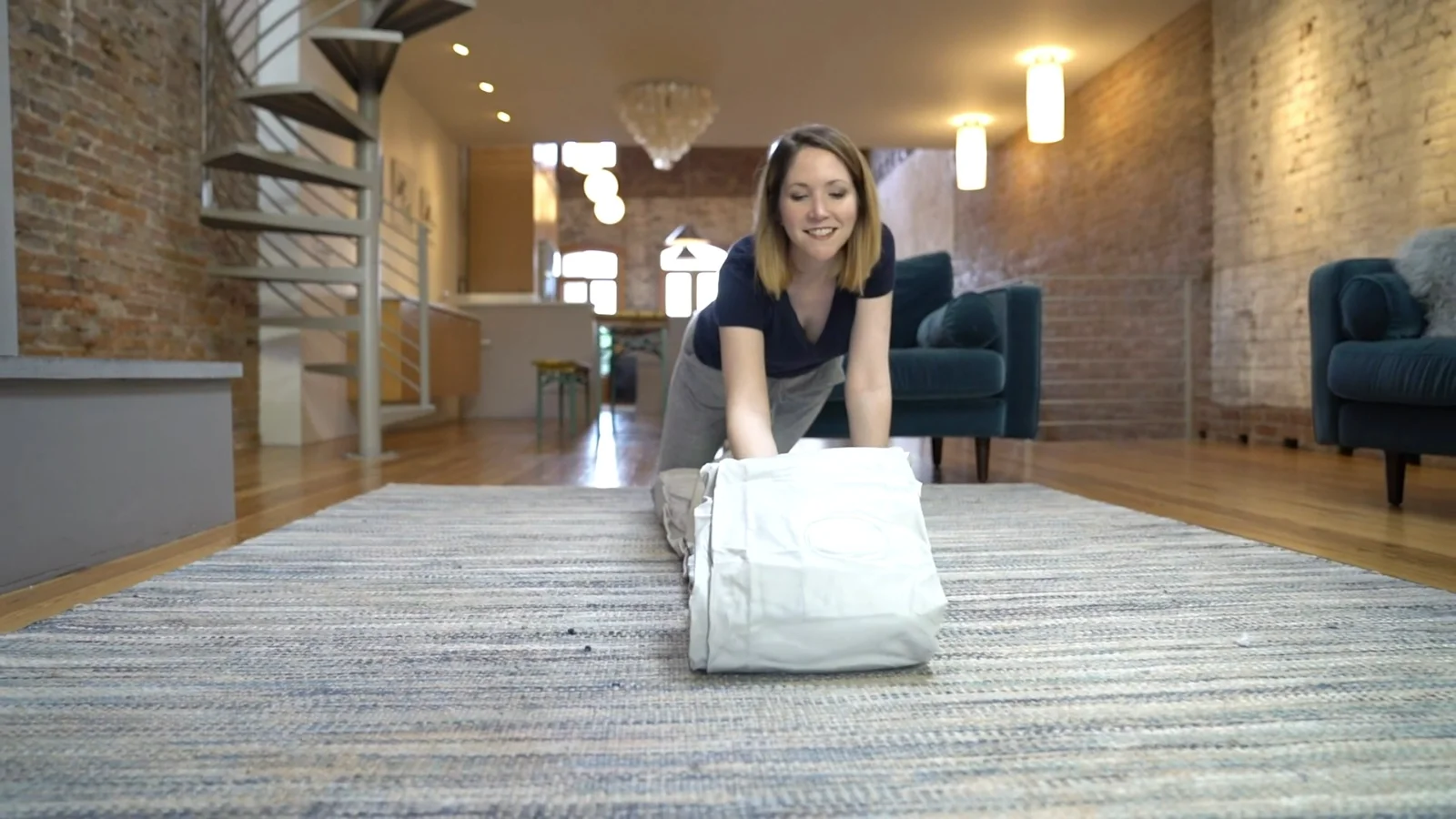 A EnerPlex queen airbed being unrolled from its carry bag onto a living room rug